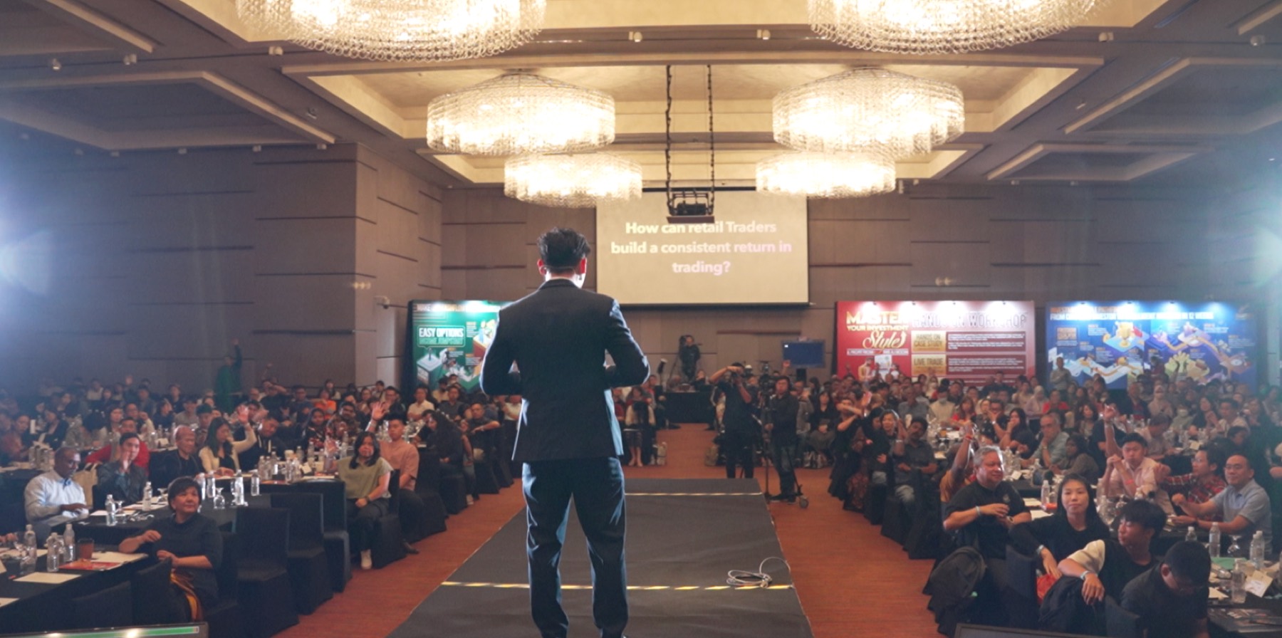 Julio speaking to a packed ballroom of investors